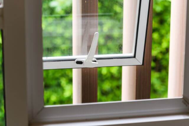 An open white window in a house.